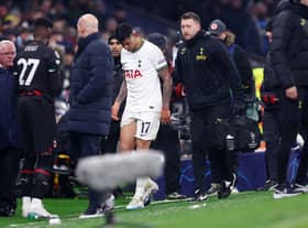 Cristian Romero of Tottenham Hotspur leaves the field with medical staff, after receiving a red card (Photo by Clive Rose/Getty Images)
