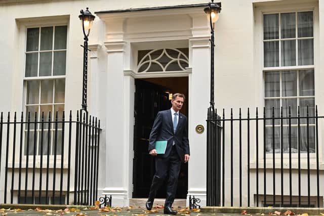 Britain's Chancellor of the Exchequer Jeremy Hunt walks out of Number 11 Downing Street