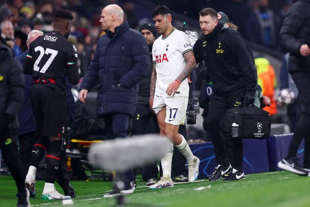 Cristian Romero of Tottenham Hotspur leaves the field with medical staff, after receiving a red card (Photo by Clive Rose/Getty Images)