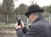 A mystery man in a bowler hat has been seen scoping out a famous site where the illusive artist Banksy left a mural that was inadvertently torn down by builders