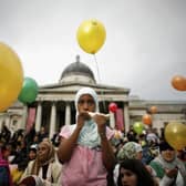 A young Muslim girl eats a sandwich as she looks on during Eid al-Fitr festivities on October 28, 2006 in London, England. (Photo by Daniel Berehulak/Getty Images)