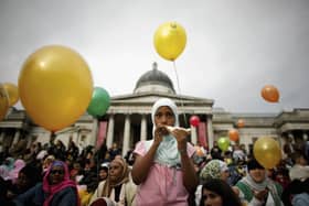 A young Muslim girl eats a sandwich as she looks on during Eid al-Fitr festivities on October 28, 2006 in London, England. (Photo by Daniel Berehulak/Getty Images)