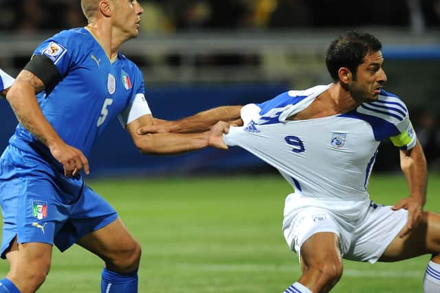 Fabio Cannavaro battles for the ball against Ioannis Okkas in a 2010 World Cup qualifying match