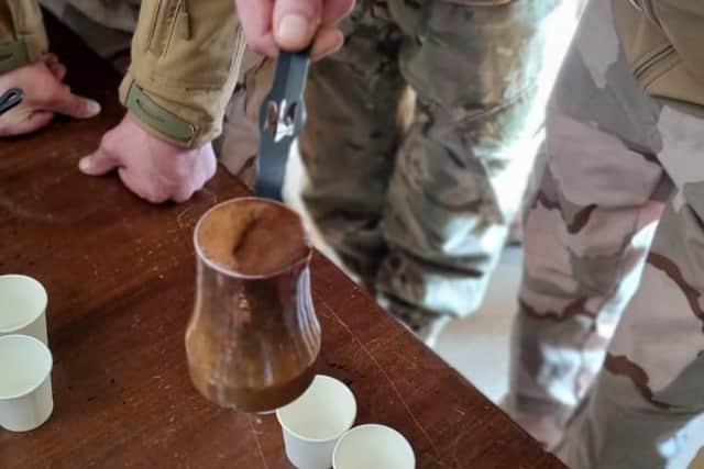 A Ukrainian soldier brewing coffee with a cezve on an open fire. Credit: Supplied