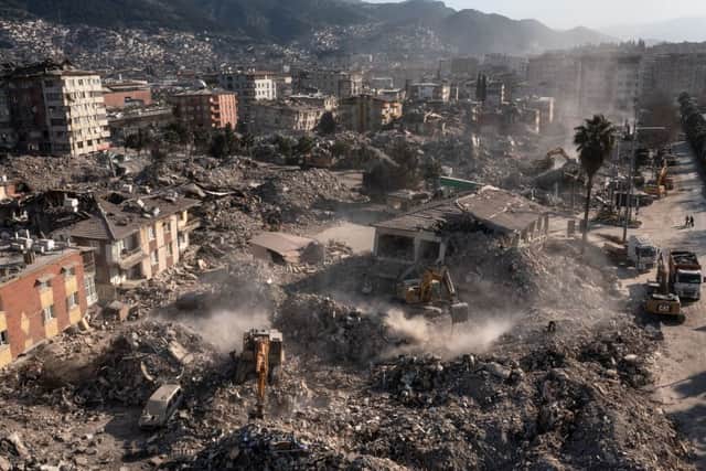 Excavators remove the debris of the earthquake-damaged buildings in Antakya, Turkey on February 17, 2023.