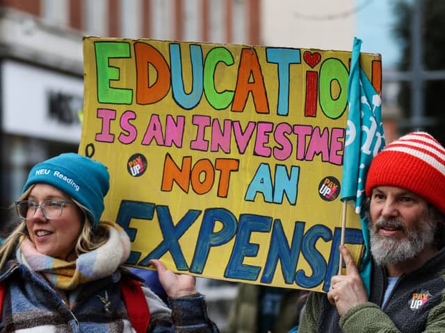 Teachers and members of the National Education Union (NEU) hold placards during a demonstration called by the NEU trade unions in the streets of Reading, on February 1, 2023 during a national strike day.  (Photo by Adrian DENNIS / AFP) (Photo by ADRIAN DENNIS/AFP via Getty Images)