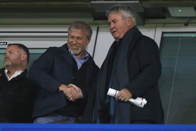 Roman Abramovich (L) shakes hands with former Chelsea manager Guus Hiddink during a UEFA Champions League Group C football match 
