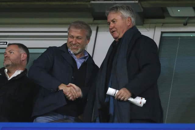 Roman Abramovich (L) shakes hands with former Chelsea manager Guus Hiddink during a UEFA Champions League Group C football match