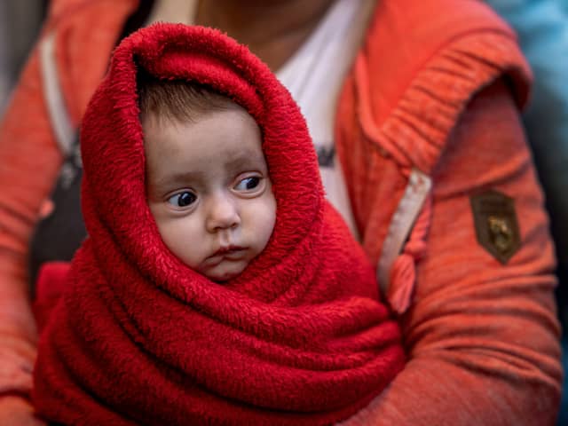 A Ukrainian woman holds her 3-month-old baby at the Western Railway Station as they flee Ukraine on March 9, 2022 in Budapest, Hungary. 