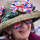 A royal fan wearing a hat covered with Union Jack themed items waits on The Mall. (Photo by LOIC VENANCE/AFP via Getty Images)