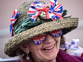 A royal fan wearing a hat covered with Union Jack themed items waits on The Mall. (Photo by LOIC VENANCE/AFP via Getty Images)