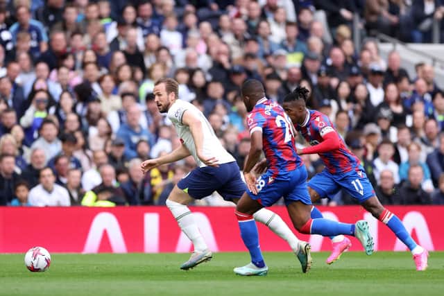 Harry Kane sprints past Cheick Doucoure and Wilfried Zaha of Crystal Palace. (Photo by Warren Little/Getty Images)