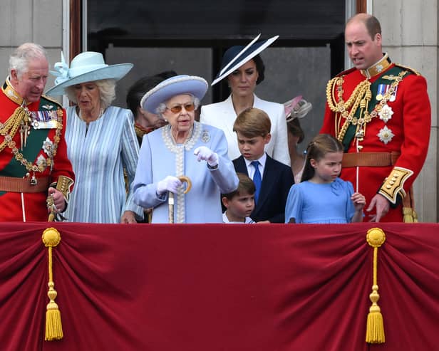 Britain's Queen Elizabeth II (C) stands with from left, Britain's Prince Charles, Prince of Wales, Britain's Prince Louis of Cambridge, Britain's Catherine, Duchess of Cambridge, Britain's Prince George of Cambridge, Britain's Princess Charlotte of Cambridge, and Britain's Prince William, Duke of Cambridge, to watch a special flypast from Buckingham Palace balcony following the Queen's Birthday Parade, the Trooping the Colour, as part of Queen Elizabeth II's platinum jubilee celebrations, in London on June 2, 2022.  (Photo by DANIEL LEAL/AFP via Getty Images)