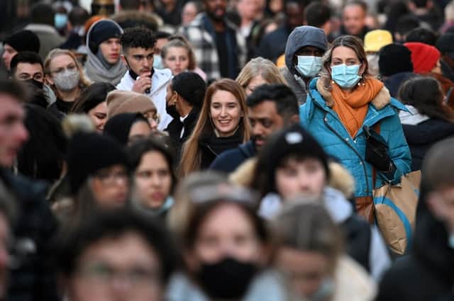 Shoppers, some wearing face-masks, walk along Oxford Street in central London (Getty Images)