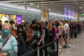 Travellers wait in a long queue to pass through the security check at Heathrow