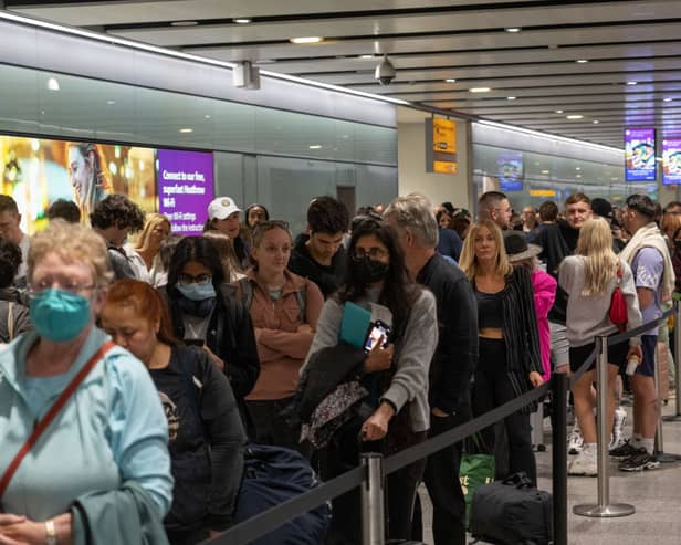 Travellers wait in a long queue to pass through the security check at Heathrow