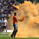 Just Stop Oil protesters thrown orange paint onto the pitch at Twickenham Stadium. Credit: Just Stop Oil