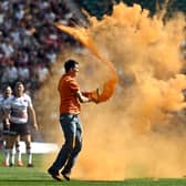 Just Stop Oil protesters thrown orange paint onto the pitch at Twickenham Stadium. Credit: Just Stop Oil