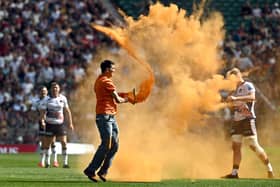 Just Stop Oil protesters thrown orange paint onto the pitch at Twickenham Stadium. Credit: Just Stop Oil