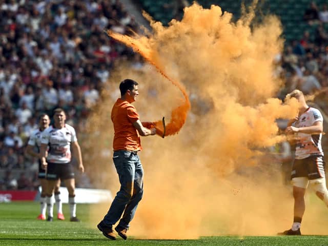 Just Stop Oil protesters thrown orange paint onto the pitch at Twickenham Stadium. Credit: Just Stop Oil