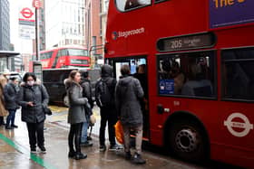 People queue to board a London bus. Credit: Tolga Akmen/AFP via Getty Images.