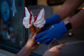 A woman serves ice cream from an van.  (Photo by Justin Setterfield/Getty Images)