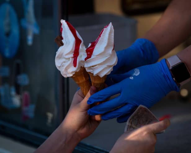 A woman serves ice cream from an van.  (Photo by Justin Setterfield/Getty Images)