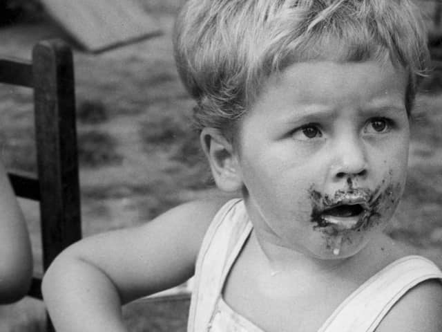 Chocolate biscuits and milk dribble down the face of a young member of the Stork Club (Nursery), Surbiton, in 1945.  (Photo by William Vanderson/Fox Photos/Getty Images)