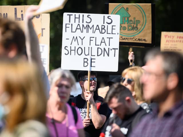 Supporters of leasehold reform campaign groups hold placards as they protest outside the Houses of Parliament. Credit: Leon Neal/Getty Images.