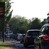 A sign advises motorists to turn off their vehicle engines when in stationary traffic, due to the high levels of pollution, on the A4 road heading out of central London. Credit: Justin Tallis/AFP via Getty Images.