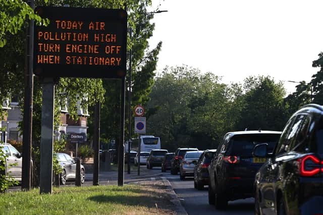 A sign advises motorists to turn off their vehicle engines when in stationary traffic, due to the high levels of pollution, on the A4 road heading out of central London. Credit: Justin Tallis/AFP via Getty Images.