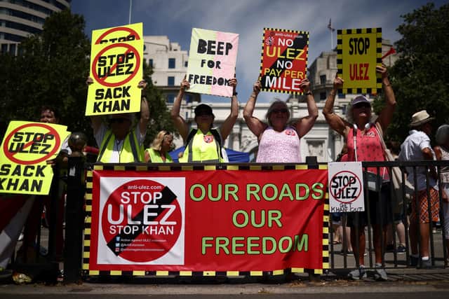 Demonstrators hold placards against London mayor Sadiq Khan and chant slogans during a rally to protest against the expansion of the ULEZ in London. Credit: Henry Nicholls/AFP via Getty Images.