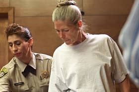 Corrections officer Sandra Fuentes (L) assists inmate Leslie Van Houten (R) as arrives for her parole hearing before members of the Board of Prison Terms 28 June 2002 at the California Institution for Women in Corona, California.