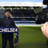 Chelsea’s Argentinian head coach Mauricio Pochettino poses for a photograph with a Chelsea scarf beside the pitch at Stamford Bridge (Photo by HENRY NICHOLLS/AFP via Getty Images)