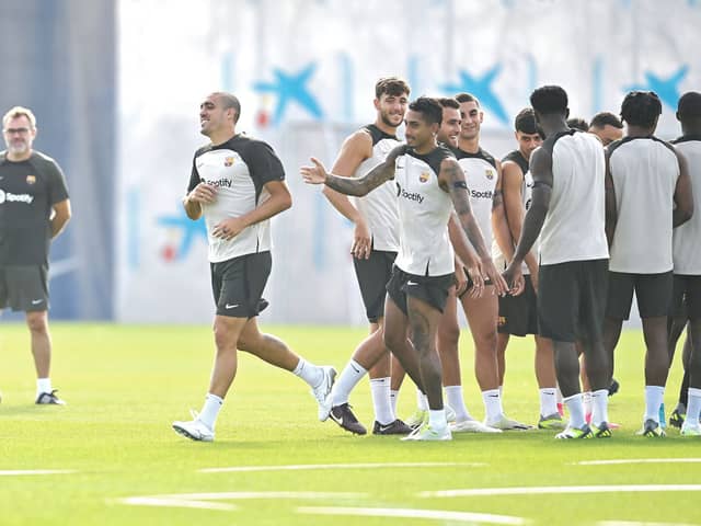 Barcelona’s Spanish midfielder Oriol Romeu (L) is welcomed by teammates during a training session  (Photo by PAU BARRENA/AFP via Getty Images)