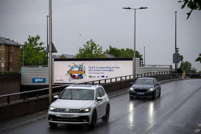 Cars pass a display informing drivers that the Ultra-Low Emission Zone (ULEZ) will expand from the end of August. Credit: Carl Court/Getty Images.