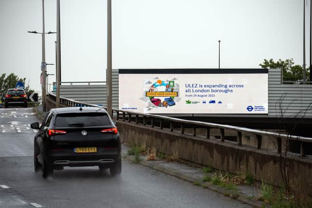 Cars pass a display informing drivers that the Ultra Low Emission Zone (ULEZ) will expand from the end of August. Credit: Carl Court/Getty Images.