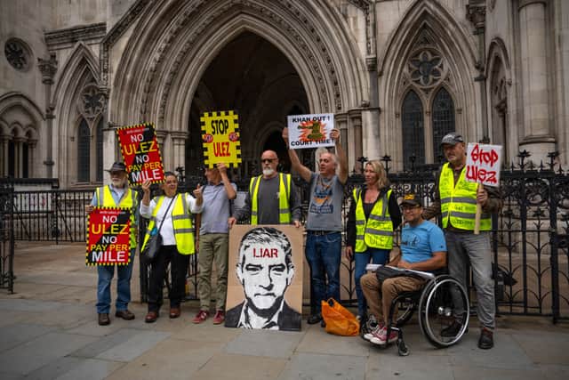 Anti-ULEZ expansion campaigners hold placards outside the High Court ahead of the ruling that the ULEZ expansion to outer London boroughs can go ahead. (Photo by Carl Court/Getty Images)
