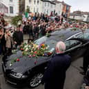People lay flowers and tributes on the hearse during the funeral procession of Sinead O’Connor in Bray. (Photo by PAUL FAITH / AFP via Getty Images)