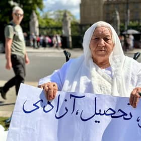 Grandmother holds placard reading ‘work, education, freedom’ in Parliament Square. Credit: Shabnam Nasimi