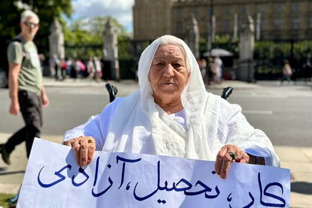 Grandmother holds placard reading ‘work, education, freedom’ in Parliament Square. Credit: Shabnam Nasimi