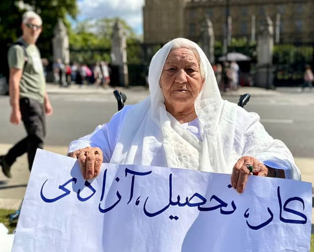 Grandmother holds placard reading ‘work, education, freedom’ in Parliament Square. Credit: Shabnam Nasimi