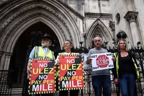 Demonstrators protest against the expansion of the Ultra Low Emission Zone (ULEZ), outside the Royal Courts of Justice in July. (Photo by HENRY NICHOLLS/AFP via Getty Images)