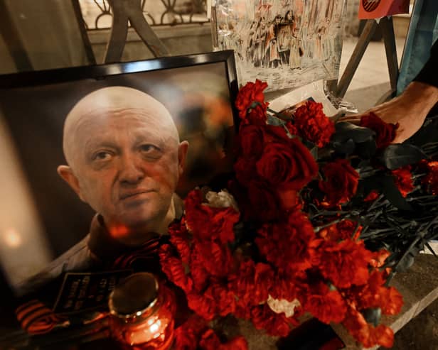  A man lays flowers at a makeshift memorial in honour of Yevgeny Prigozhin.