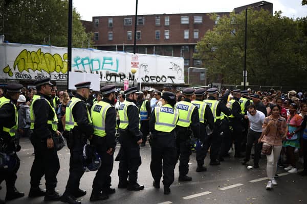 Police officers patrol during the main parade of the Notting Hill Carnival. Credit: Henry Nicholls/AFP via Getty Images.
