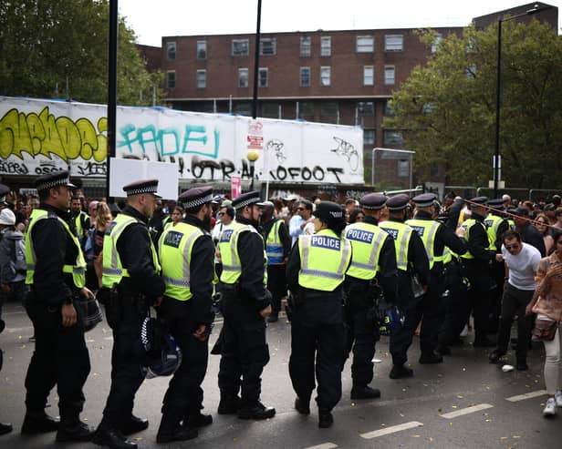 Police officers patrol during the main parade of the Notting Hill Carnival. Credit: Henry Nicholls/AFP via Getty Images.