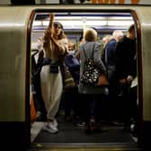 Commuters packed onto a busy Tube train.