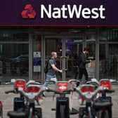 Pedestrians walk past a branch of a NatWest bank in London.