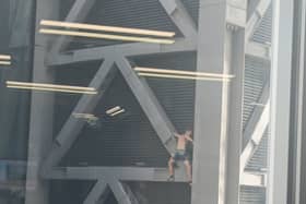 A daredevil climber scales the Cheesegrater without climbing equipment. Credit: Denika Leonard