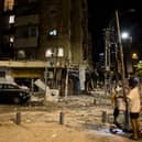 A man passes the scene where a rocket fired from Gaza strip hit a building on October 7, 2023 in Tel Aviv, Israel. Credit: Amir Levy/Getty Images.